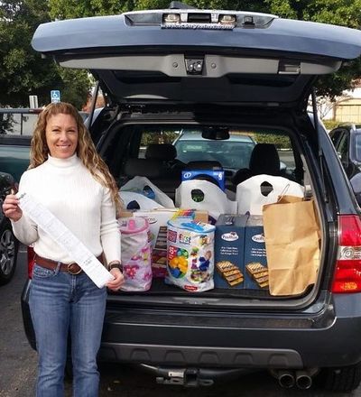 Kelly Hunt, REALTOR® with car trunk open and toys